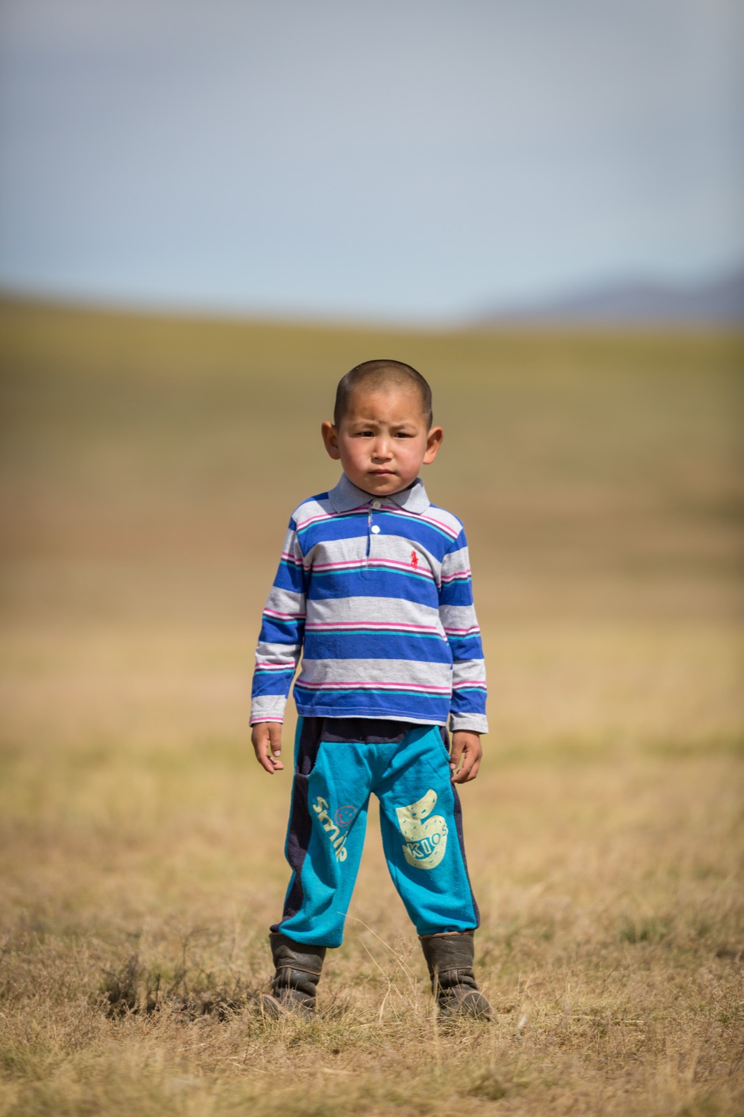Mongolian child standing in the steppe